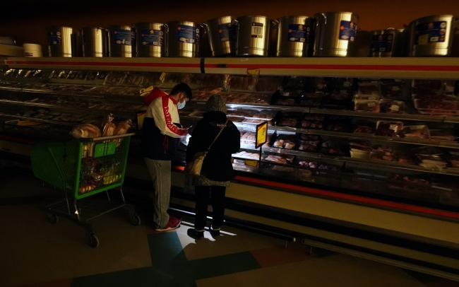 ABD'de kış koşullarına bağlı elektrik kesintilerinden en çok etkilenen Teksas eyaletinin Dallas kentindeki bir marketten alışveriş yapmaya çalışanlar cep telefonlarının ışığını kullandı. Markette sadece nakit ödeme kabul edildi. Fotoğraf: AP